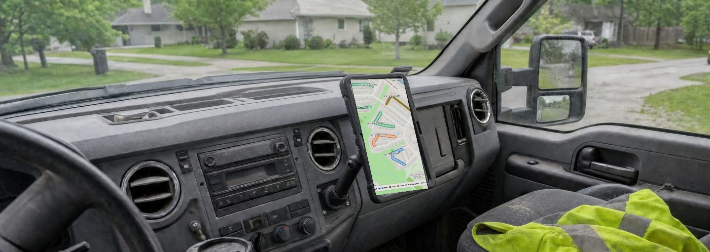 The same truck cab: the dashboard is clear and a tablet on a mount shows the Dig Window map with colour-coded dig zones.